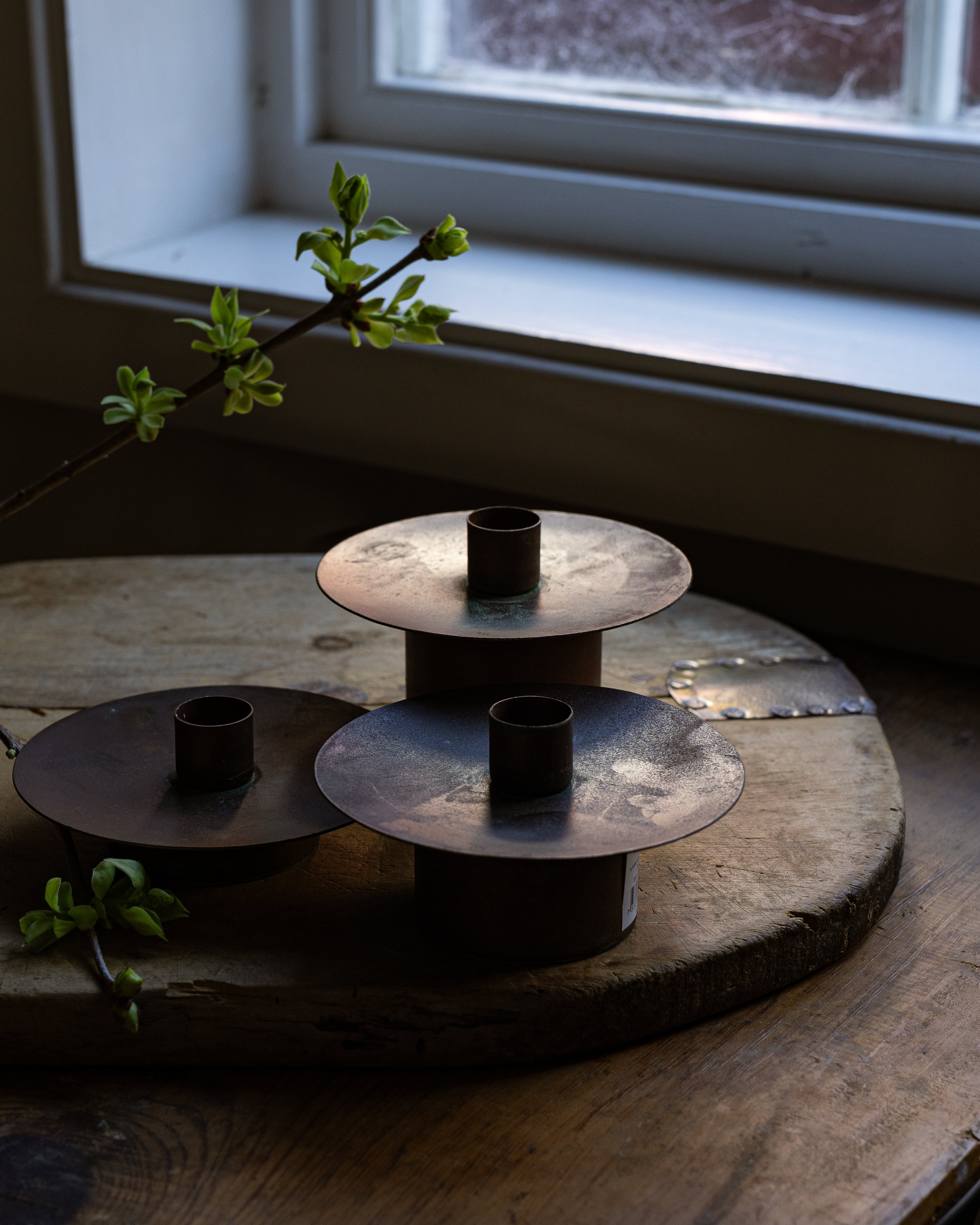 3 stk kobberlysestaker  i ulik høyde stående på en vintage brødfjøl