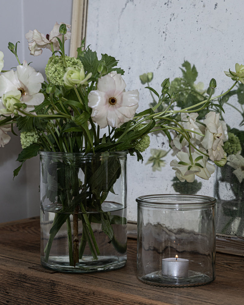 2 stk glassvaser. Den høyeste med blomster og den lille brukes som lyslykt