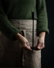 Nærbilde av hendene til en dame som holder en lysestake i smijern på 30cm