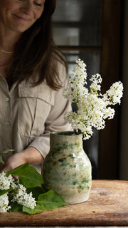 gronn-vase-med-dame-i-bakgrunnen