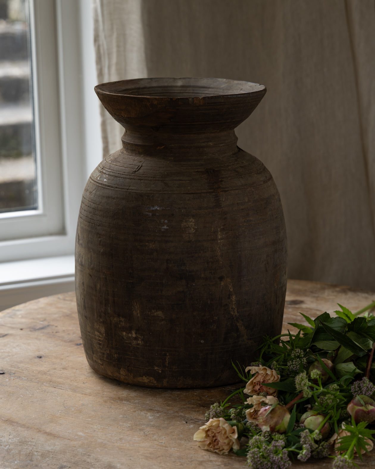 trekrukke-med-blomster-liggende-ved-siden-av