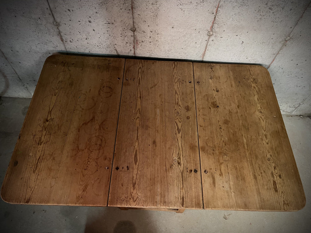 Bordplate sett ovenfra av antikt spisebord i massivt heltre med begge klaffer slått opp