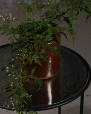 Antikt rundt sidebord fra Snowdrops Copenhagen med patinert metalloverflate og sort ramme.