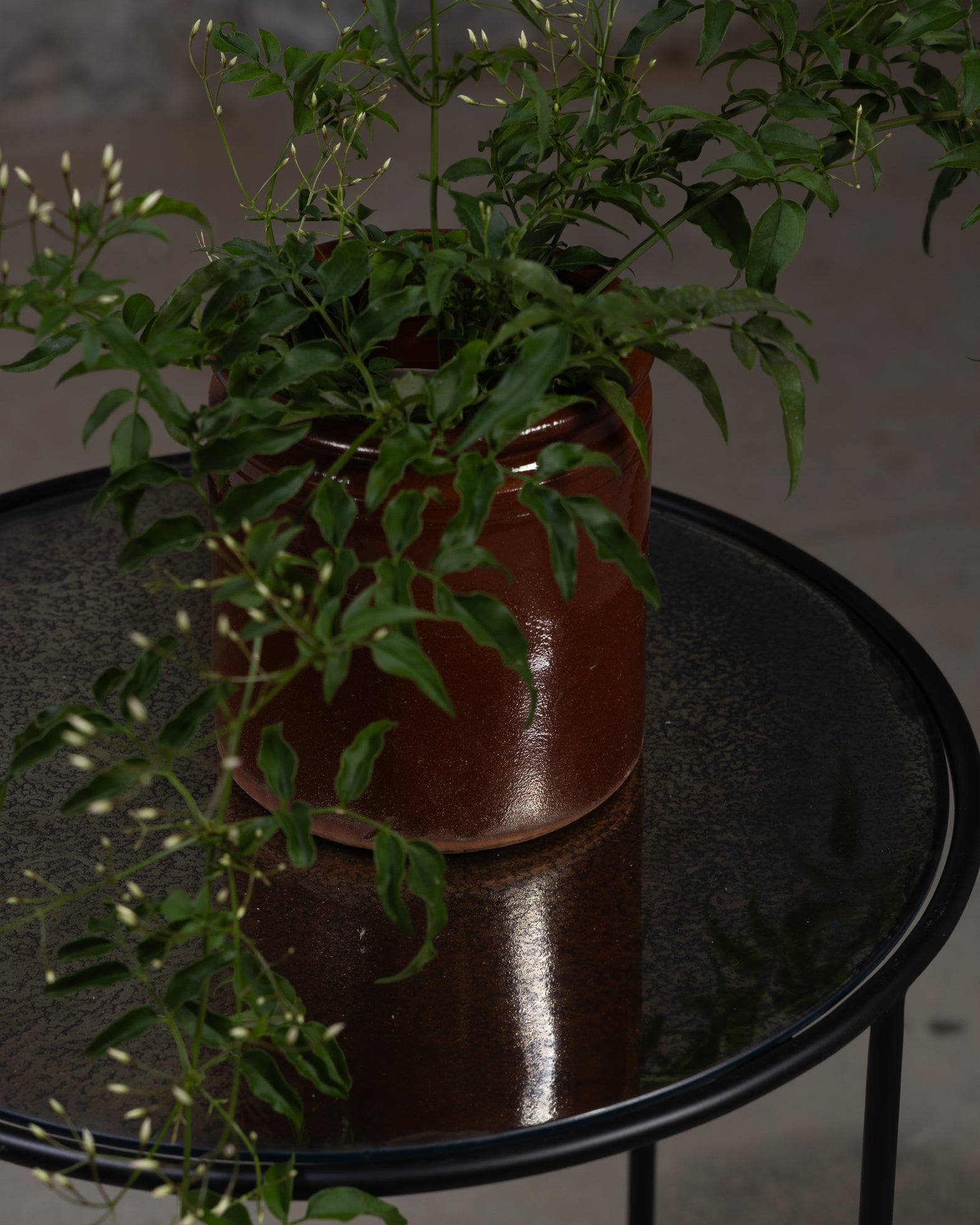 Antikt rundt sidebord fra Snowdrops Copenhagen med patinert metalloverflate og sort ramme.