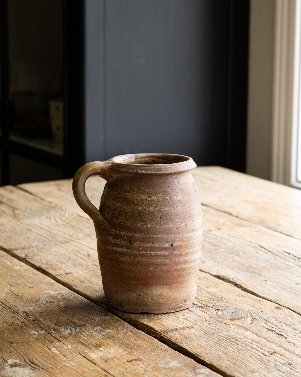 beige-krukke-med-patina-paa-trebord