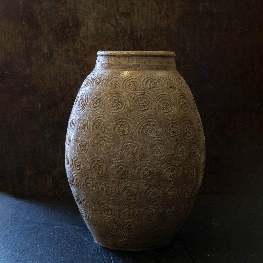 vintage-vase-med-monster-staende-pa-bord