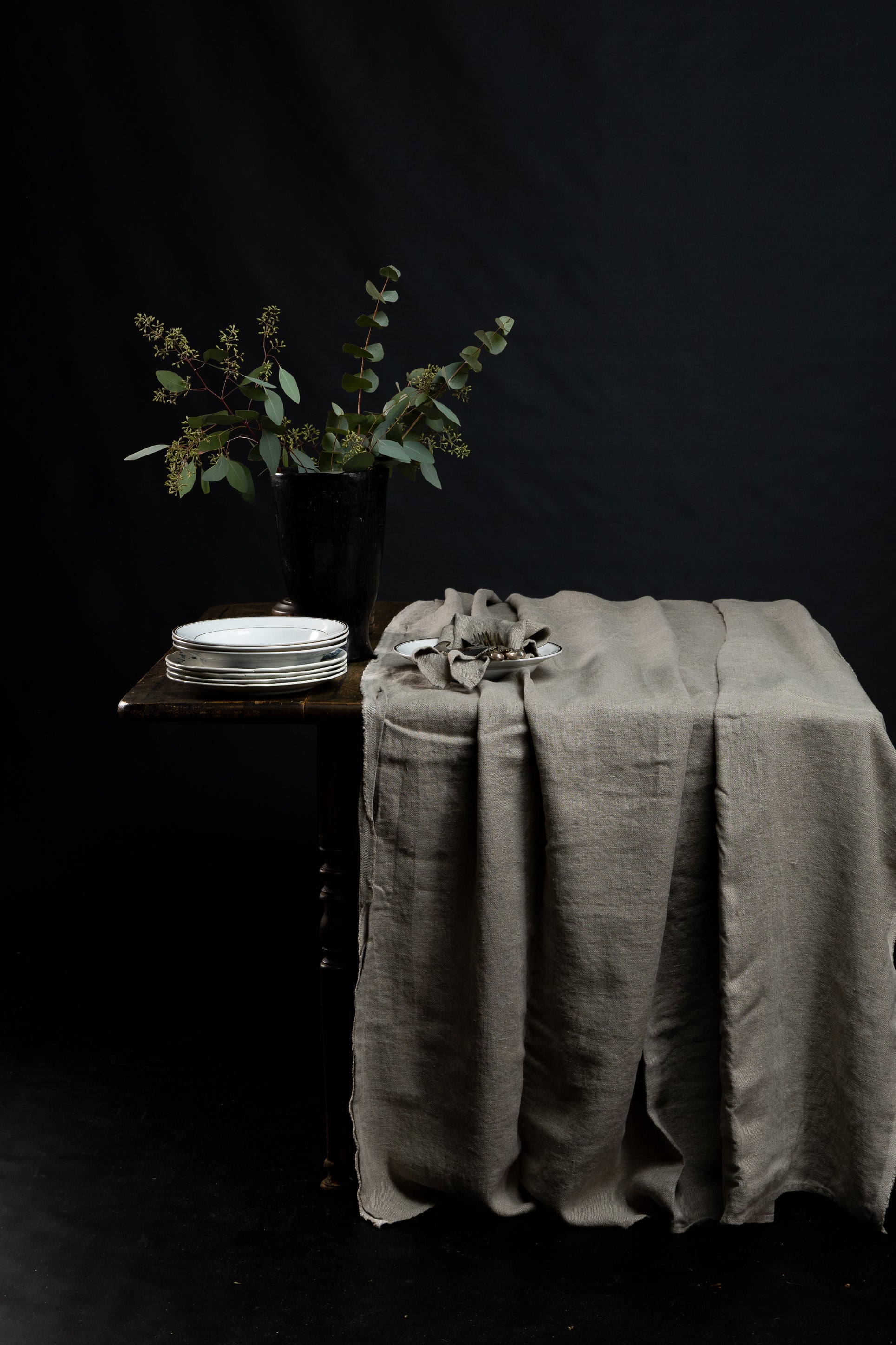 duk-naturfarget-paa-trebord-med-tallerken-og-blomst