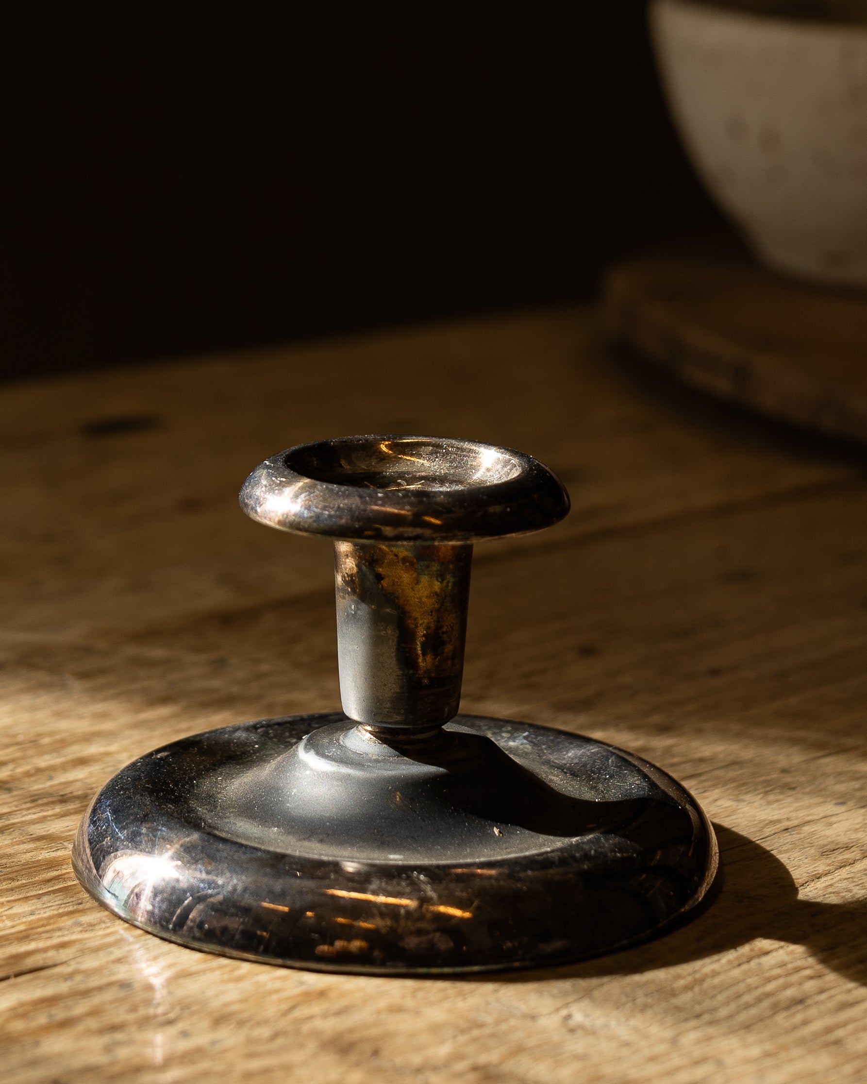 vintage-lysestake-staaende-paa-bord-i-solskinn