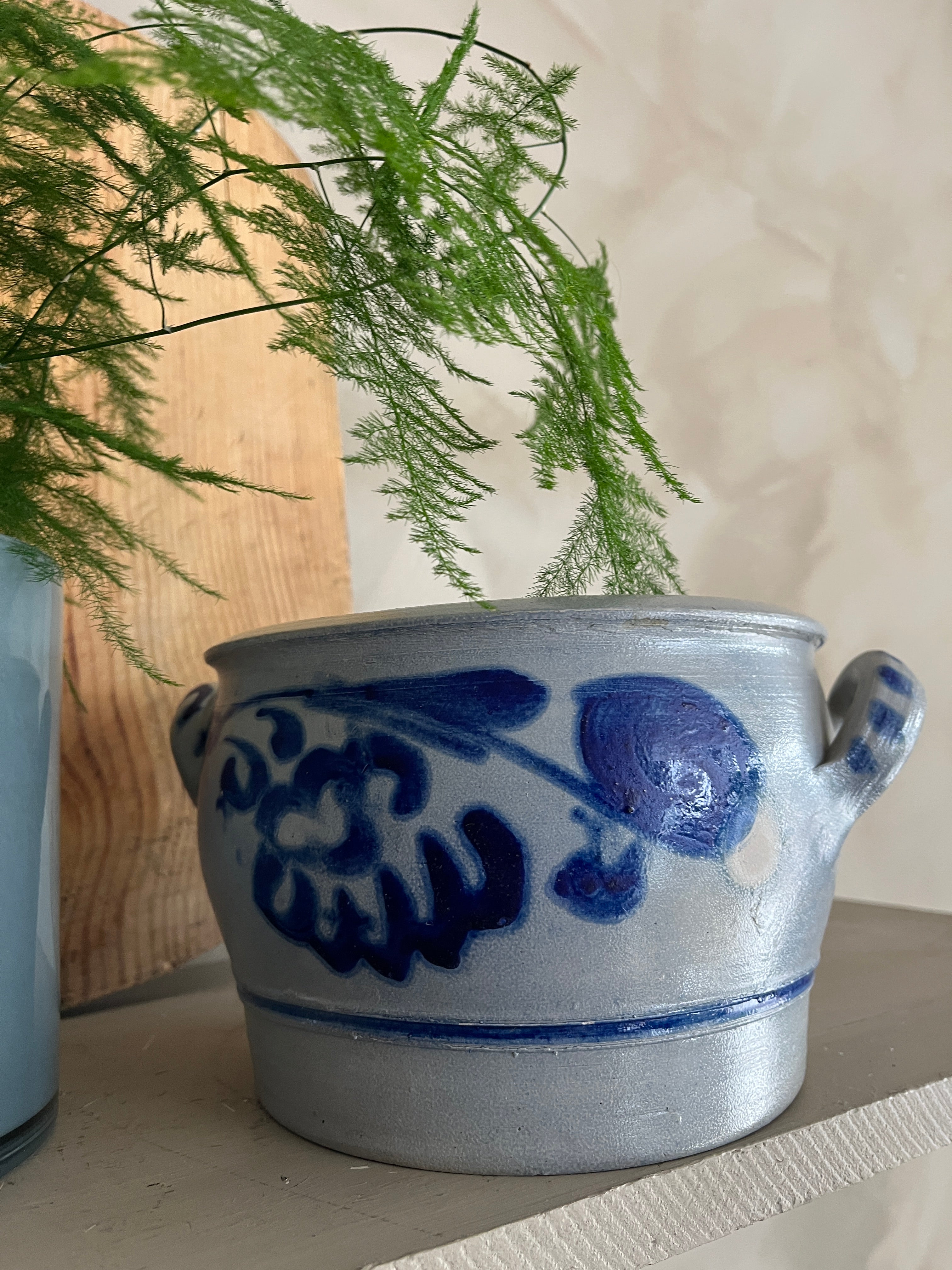 naerbilde-av-krukke-paa-hylle-med-blomst