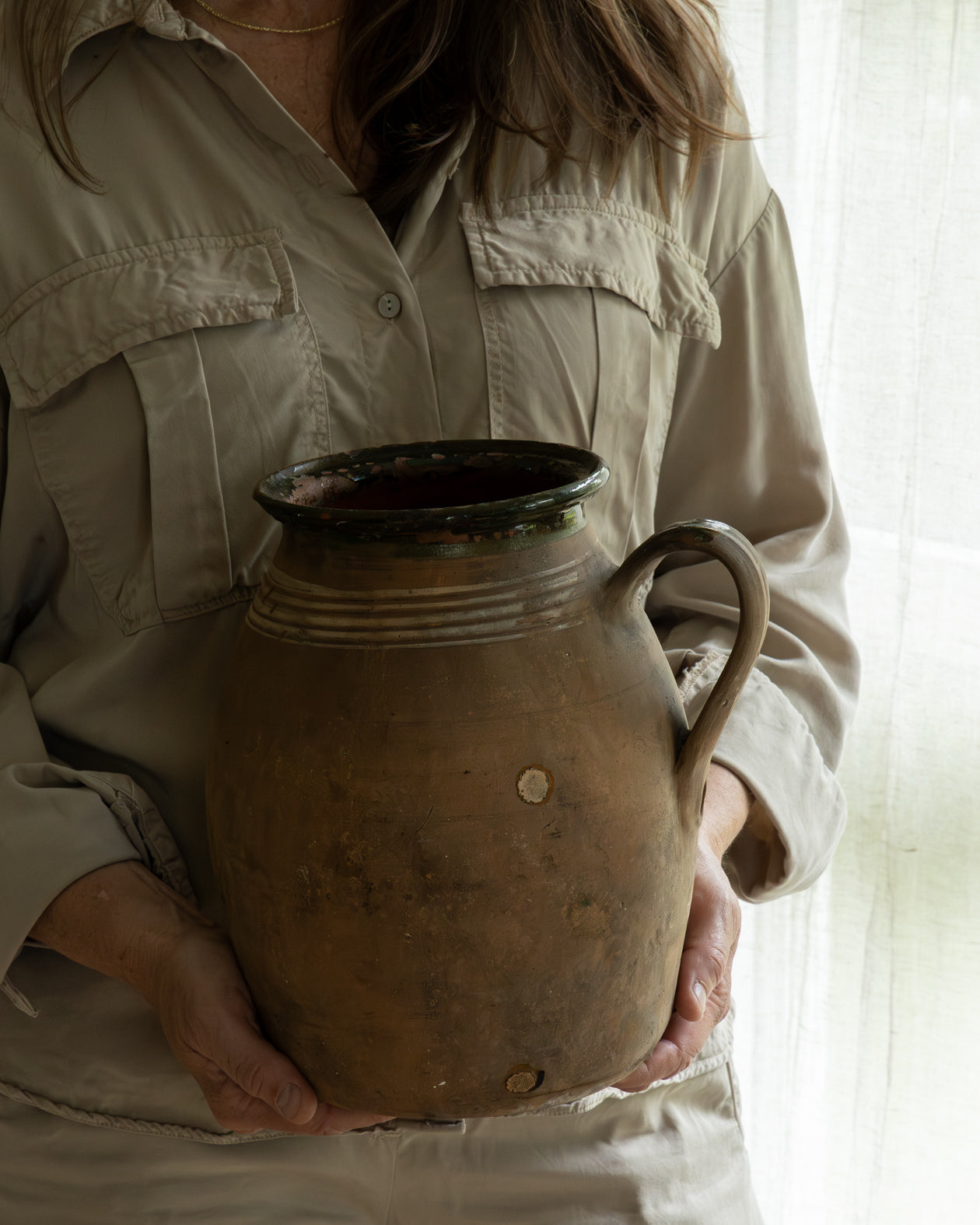 person-som-holder-en-vintage-krukke