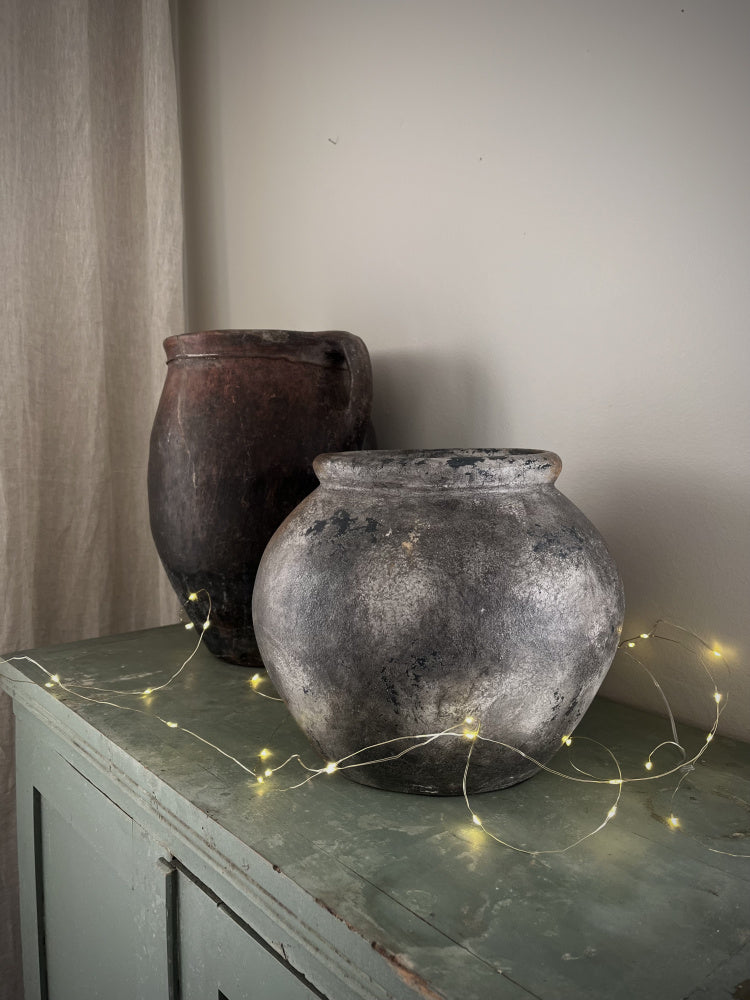 Sirius lyslenke 3,9 meter 40 leds liggende på toppen av et skap sammen med to vintage krukker 