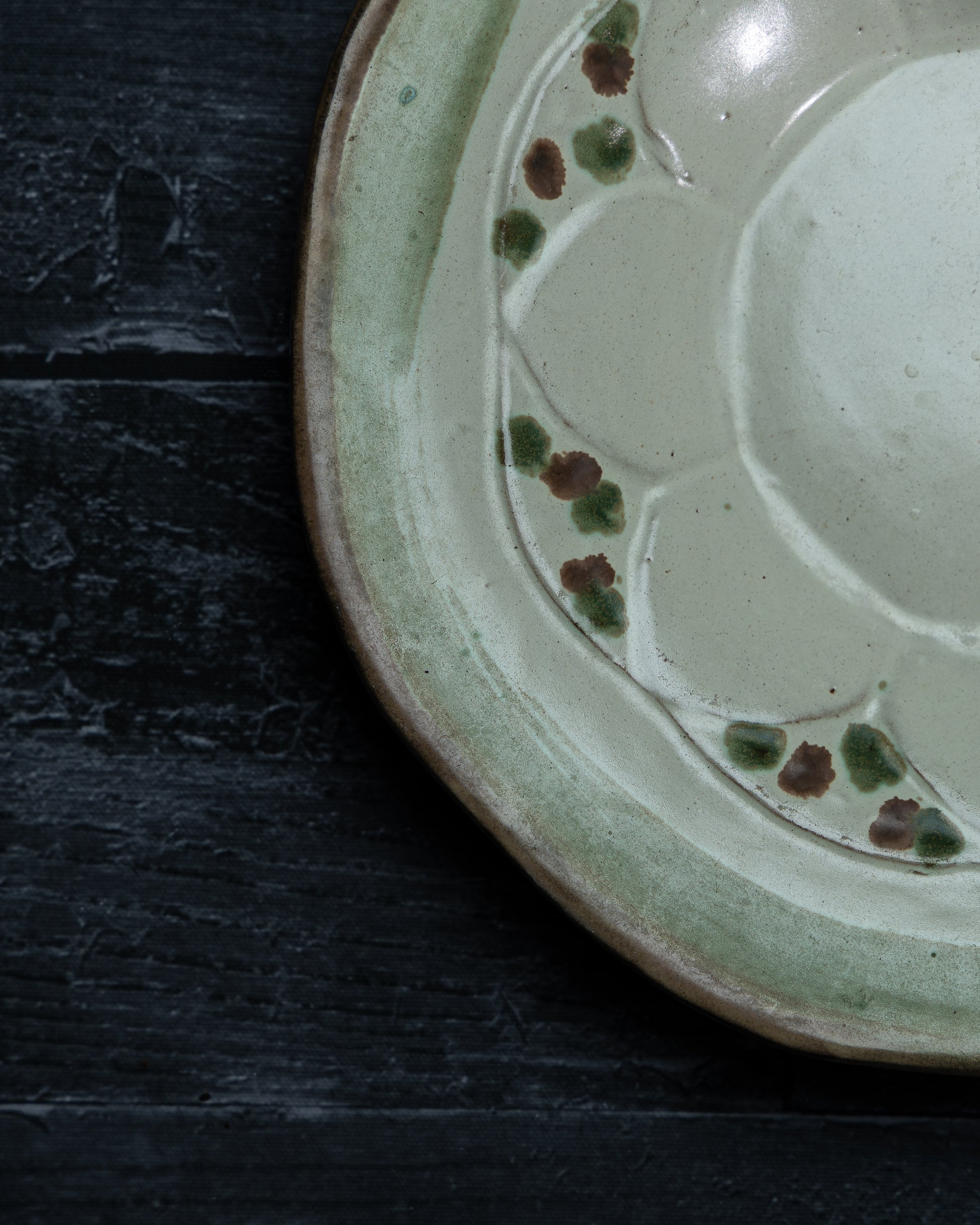 naerbilde-av-beige-fat-med-gronne-og-brune-detaljer