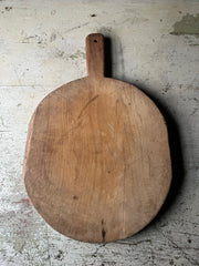 Rund vintage pizzafjøl i tre 39x35 cm med lys patina og håndtak