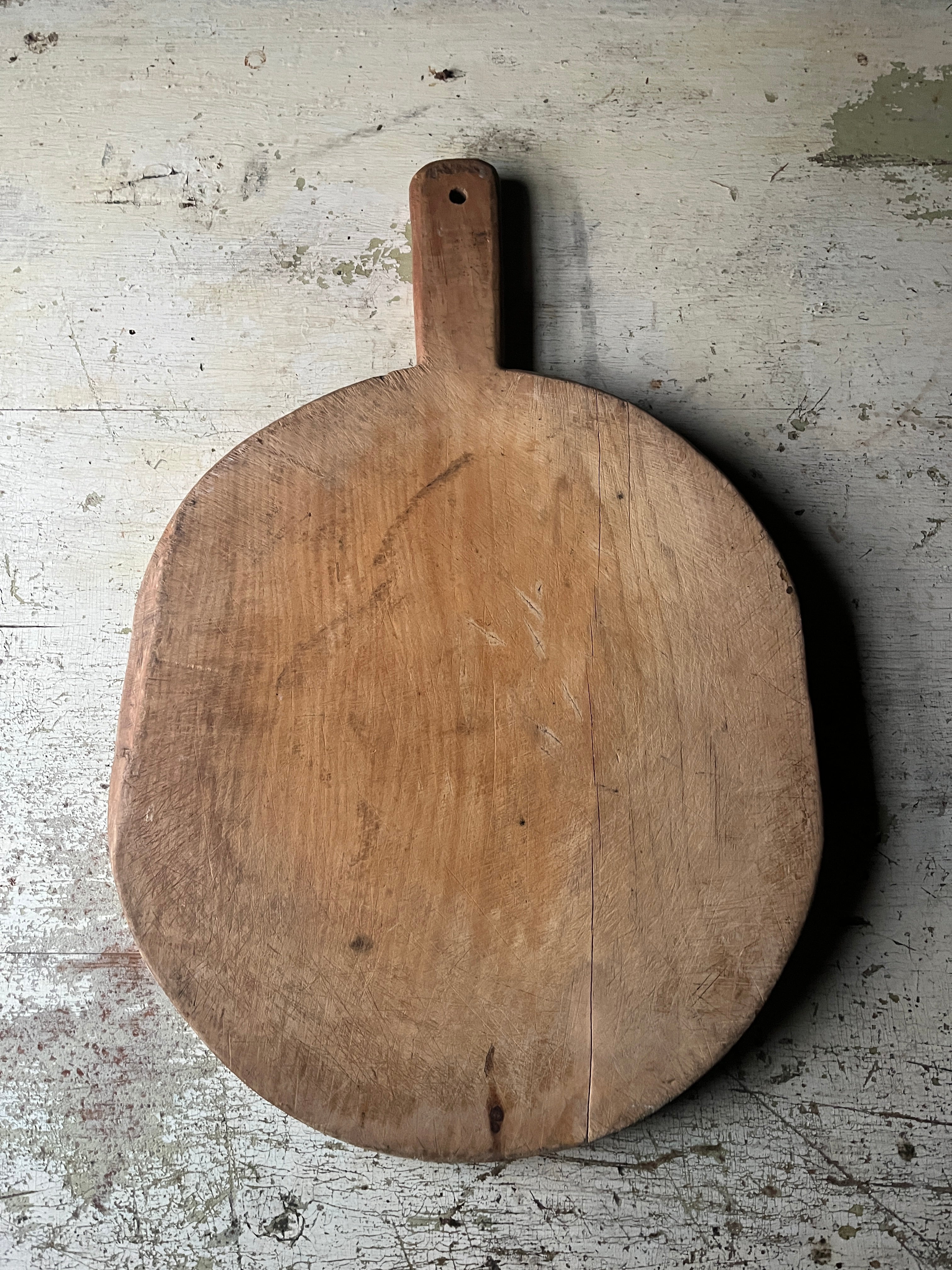 Rund vintage pizzafjøl i tre 39x35 cm med lys patina og håndtak