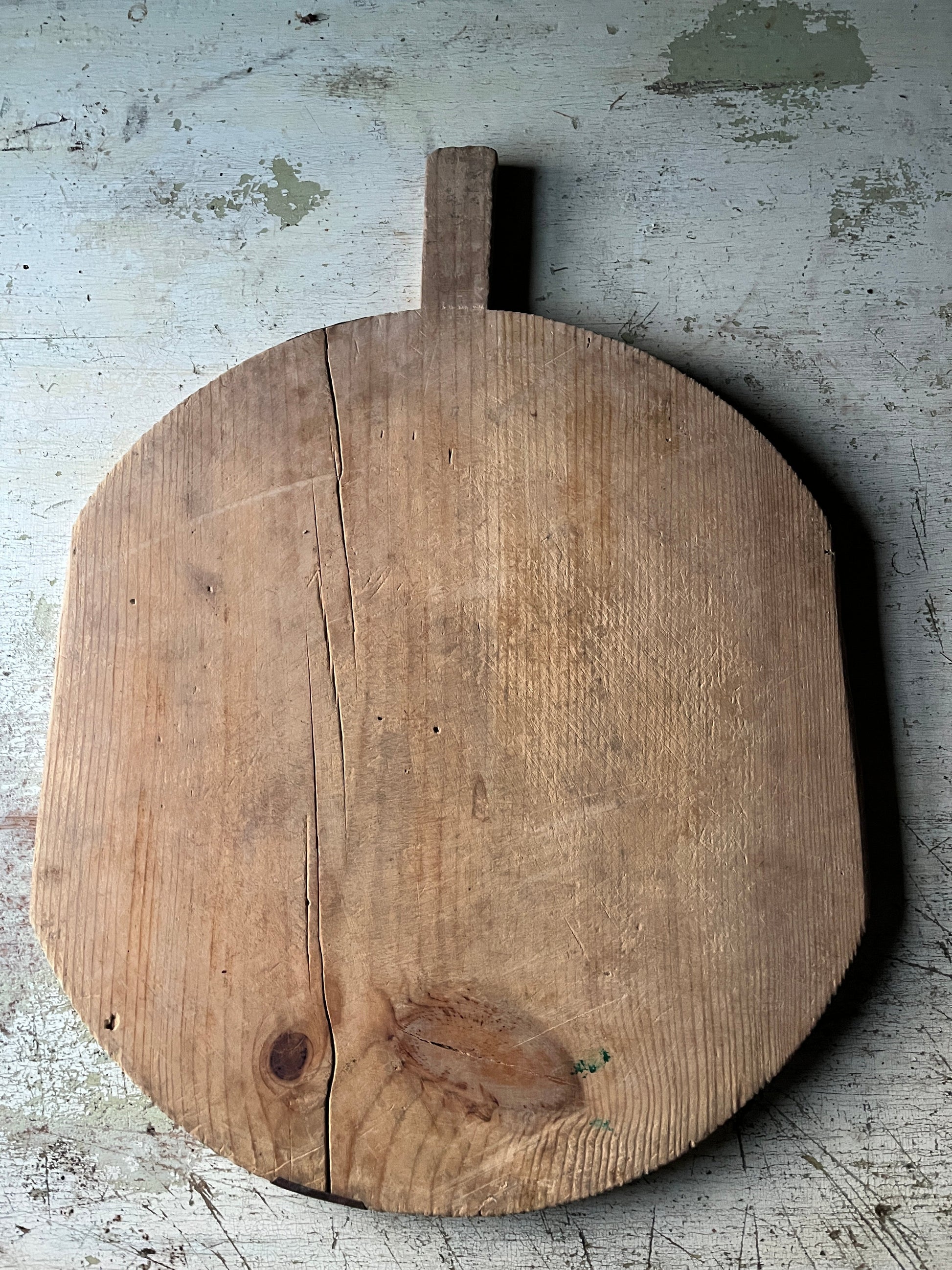 Bksiden på en rund vintage pizzafjøl i tre 49x44 cm med lys rustikk patina
