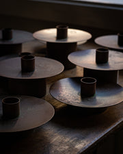 Flere kobberfarget lysestaker samlet 