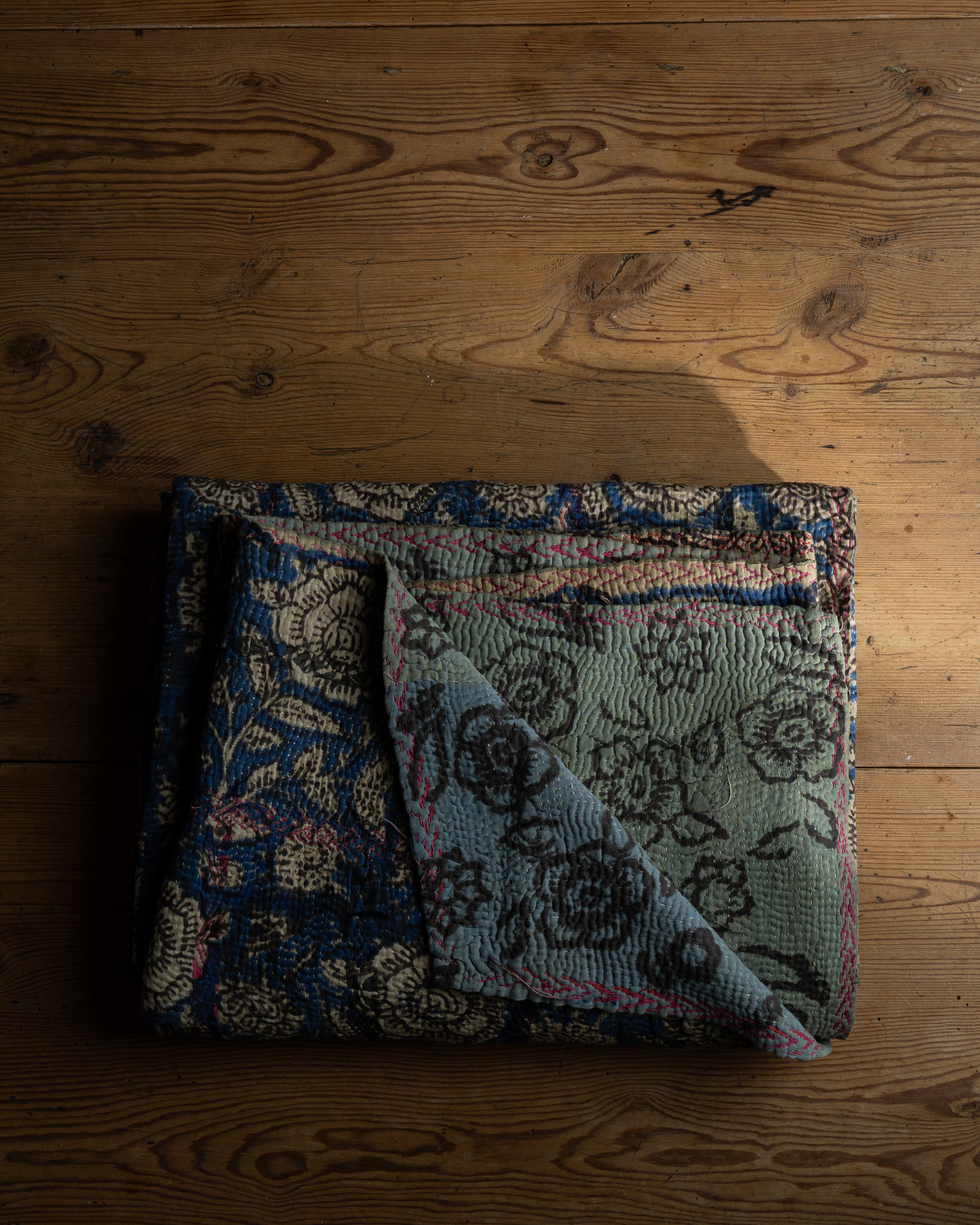 Vintage sari teppe med mønster i ulike farger: grunnfargen er blå, med beige, brune og rosa detaljer. På den andre siden er fargene grønn, brun og rosa
