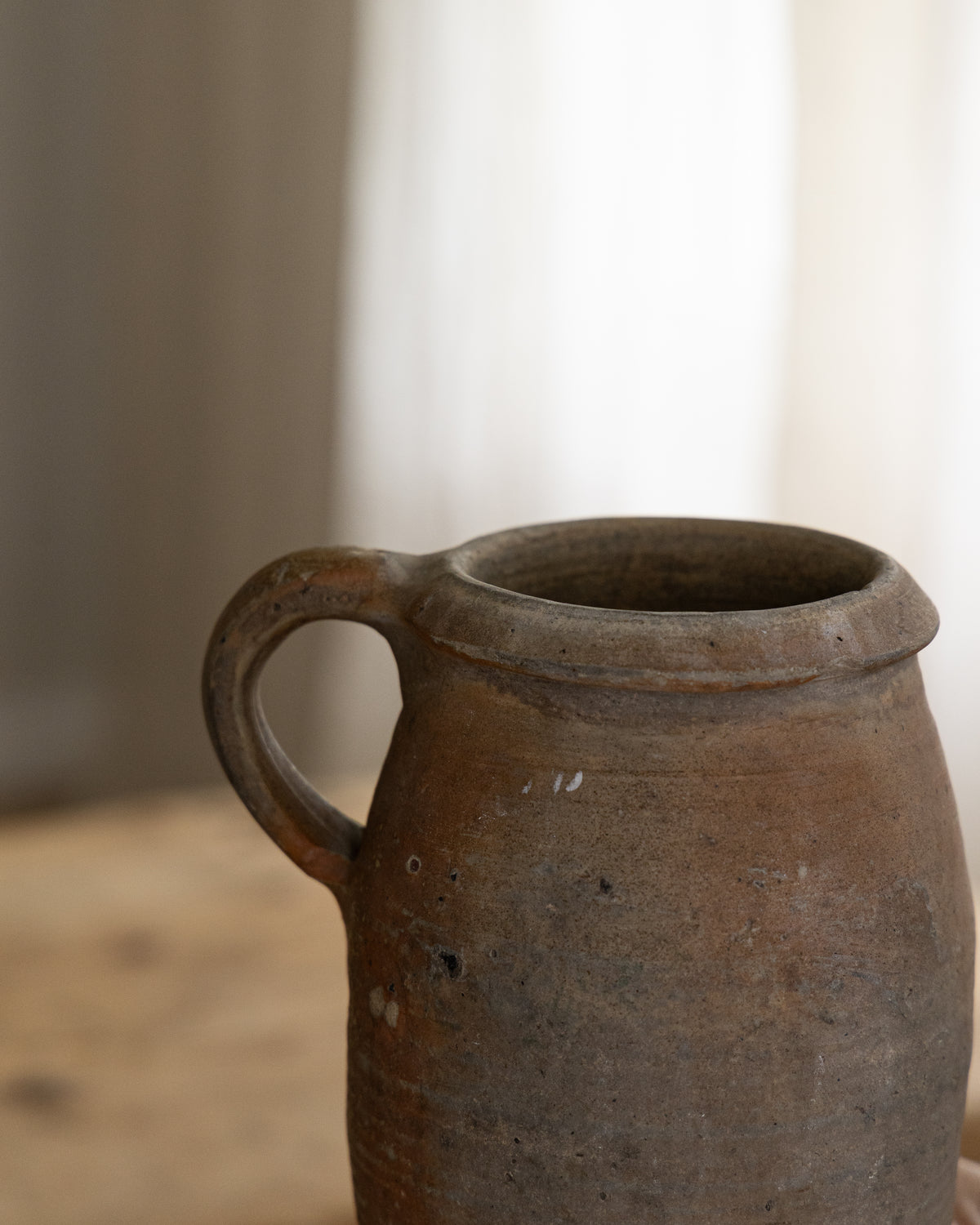 Detaljbilde av vintage krukke fra Frankrike med hank og rustikk overflate