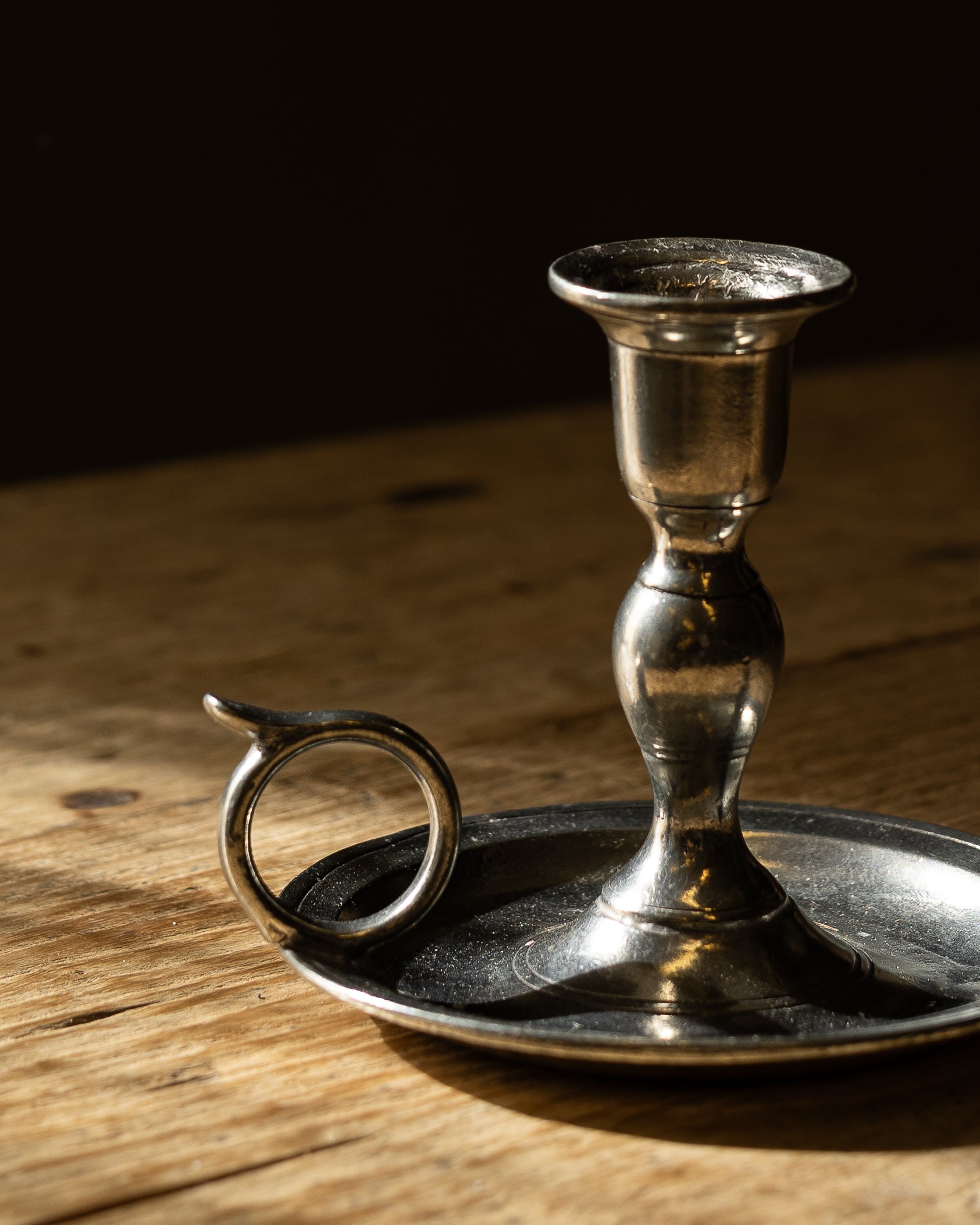 vintage-lysestake-i-tinn-staaende-paa-bord