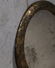 Detalbilde av et vintage rundt veggspeil med vakker patina og kraftig ramme 